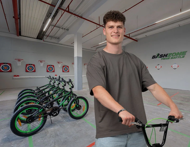 teilnehmender fahrt mit bmx raddurch einen trickparcours in der eventhalle der bashzone.